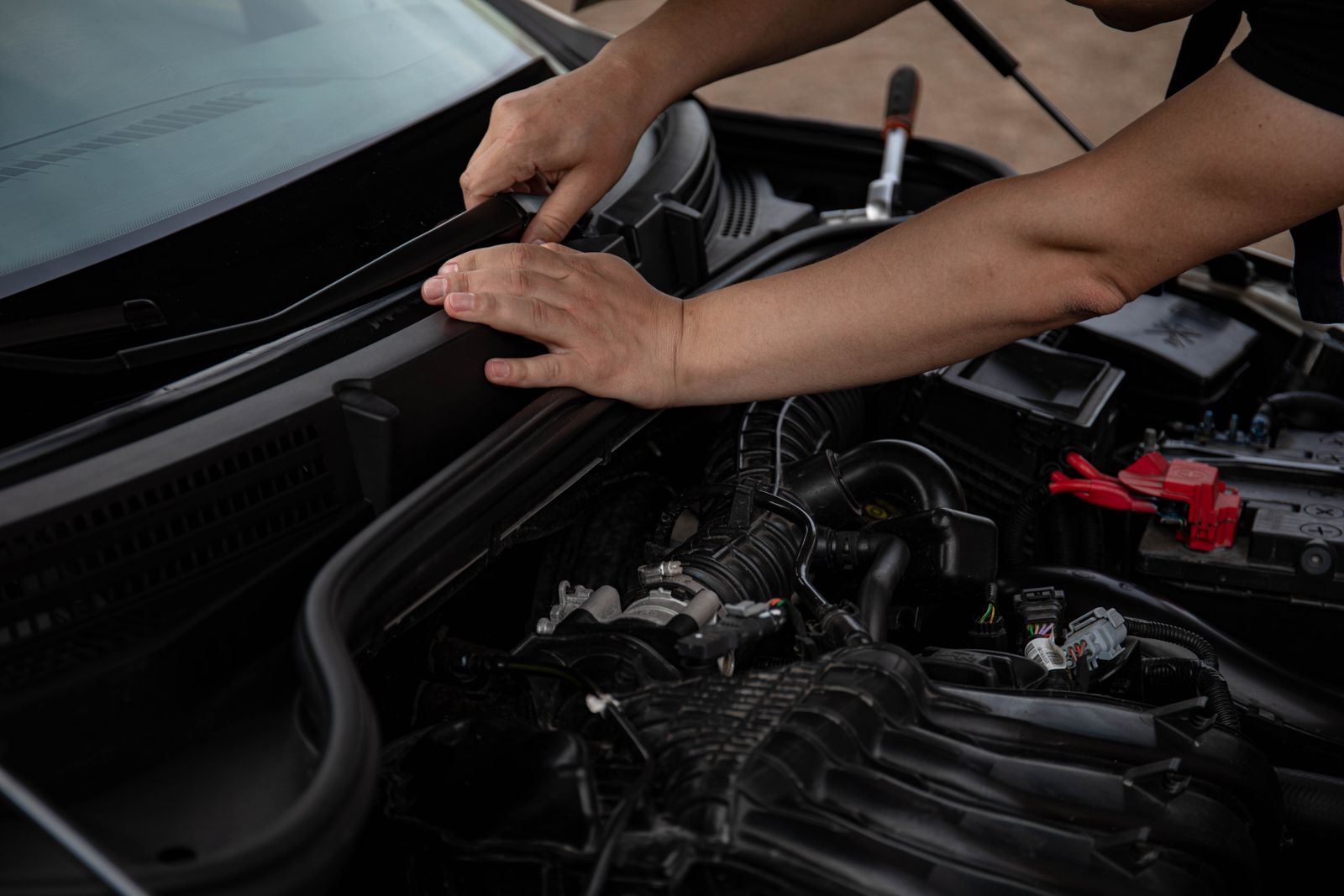 Hands inspecting a vehicle component